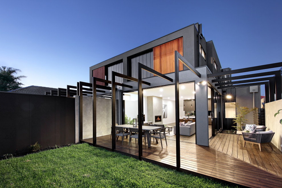 Photo of a large contemporary backyard deck in Melbourne with a container garden and a pergola.