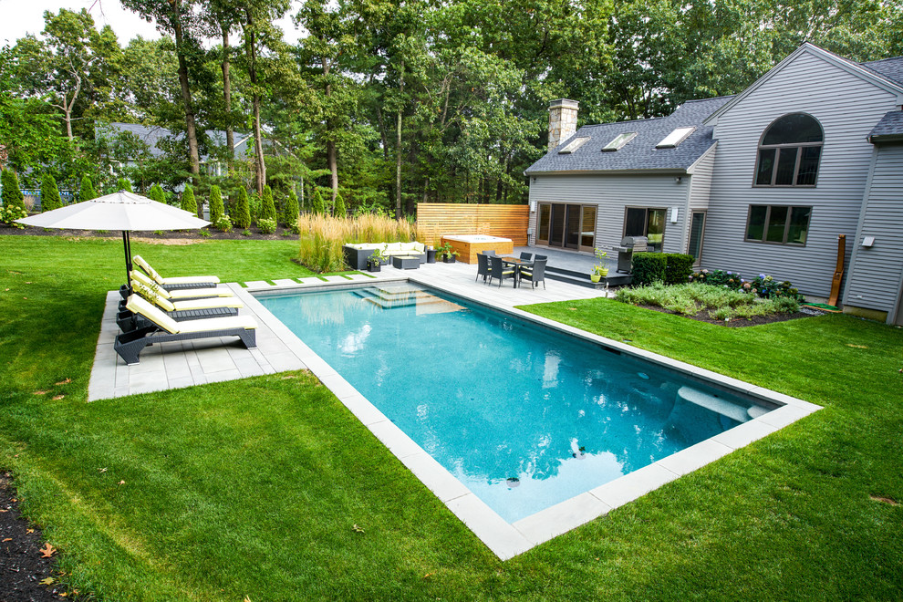 Inspiration for a mid-sized contemporary rectangular pool in Boston with natural stone pavers.