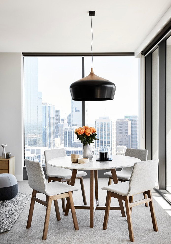 This is an example of a contemporary open plan dining in Melbourne with white walls and carpet.