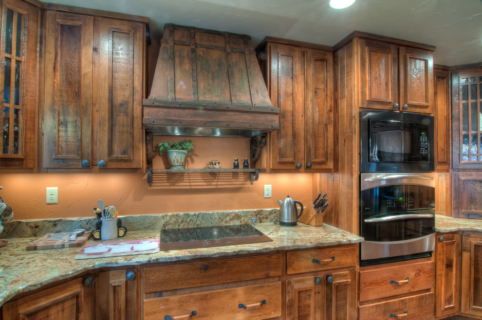 Eat-in kitchen - rustic u-shaped eat-in kitchen idea with an undermount sink, raised-panel cabinets, medium tone wood cabinets, granite countertops, beige backsplash and stainless steel appliances