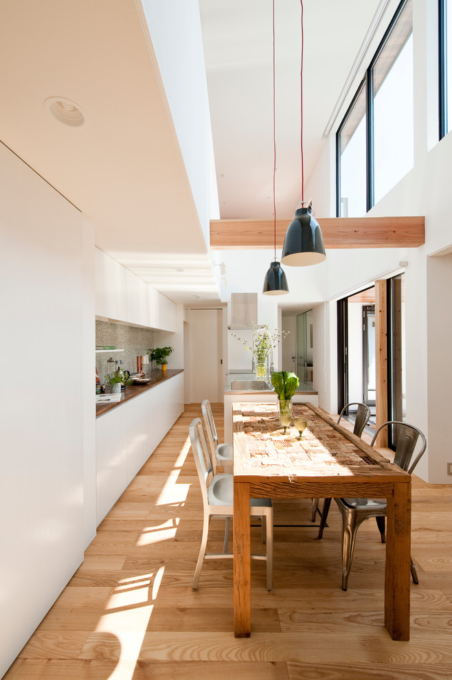 Photo of a contemporary dining room in Other with white walls and medium hardwood floors.
