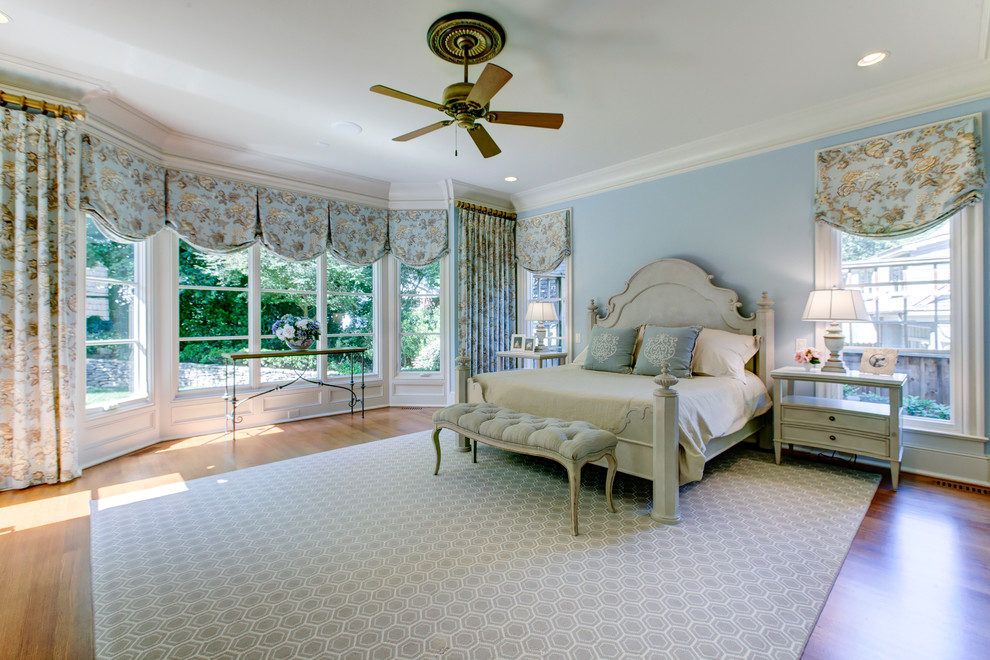 Inspiration for a large traditional master bedroom in Raleigh with blue walls, no fireplace and light hardwood floors.