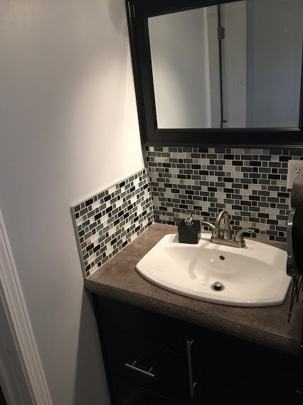 Inspiration for a small contemporary bathroom in Other with shaker cabinets, black cabinets, a two-piece toilet, black and white tile, glass sheet wall, grey walls, concrete floors, a drop-in sink and concrete benchtops.