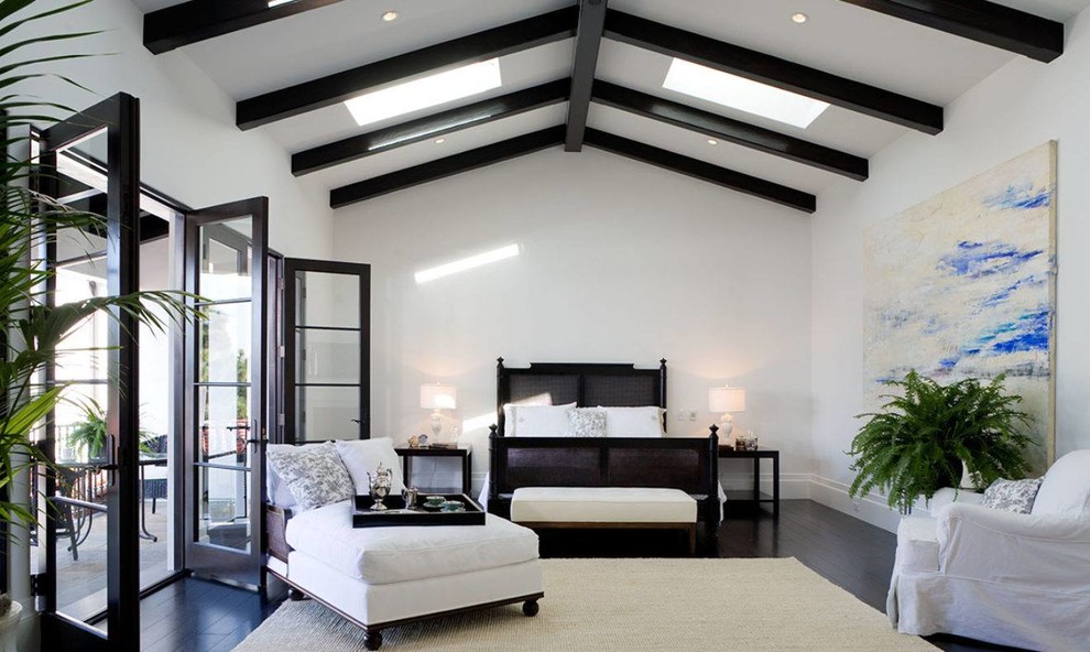 Mediterranean master bedroom in Los Angeles with white walls, dark hardwood floors and black floor.
