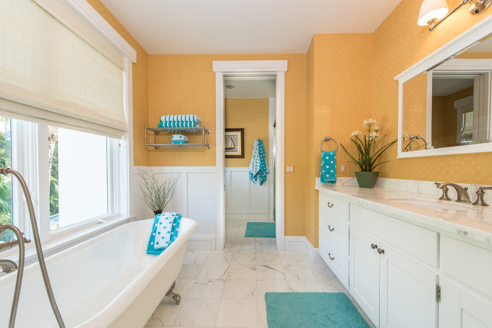 Design ideas for a traditional master bathroom in Miami with shaker cabinets, white cabinets, a claw-foot tub, stone tile, yellow walls, marble floors, an undermount sink and marble benchtops.