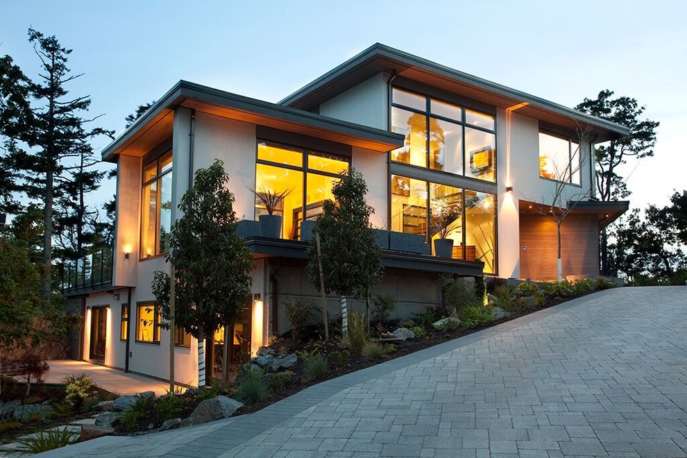 Photo of a large contemporary three-storey grey house exterior in Vancouver with mixed siding and a flat roof.