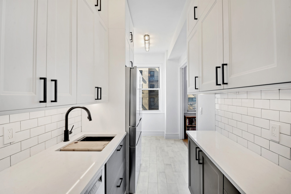 Inspiration for a large contemporary galley separate kitchen in New York with a drop-in sink, shaker cabinets, grey cabinets, quartzite benchtops, white splashback, cement tile splashback, stainless steel appliances, porcelain floors, grey floor and white benchtop.