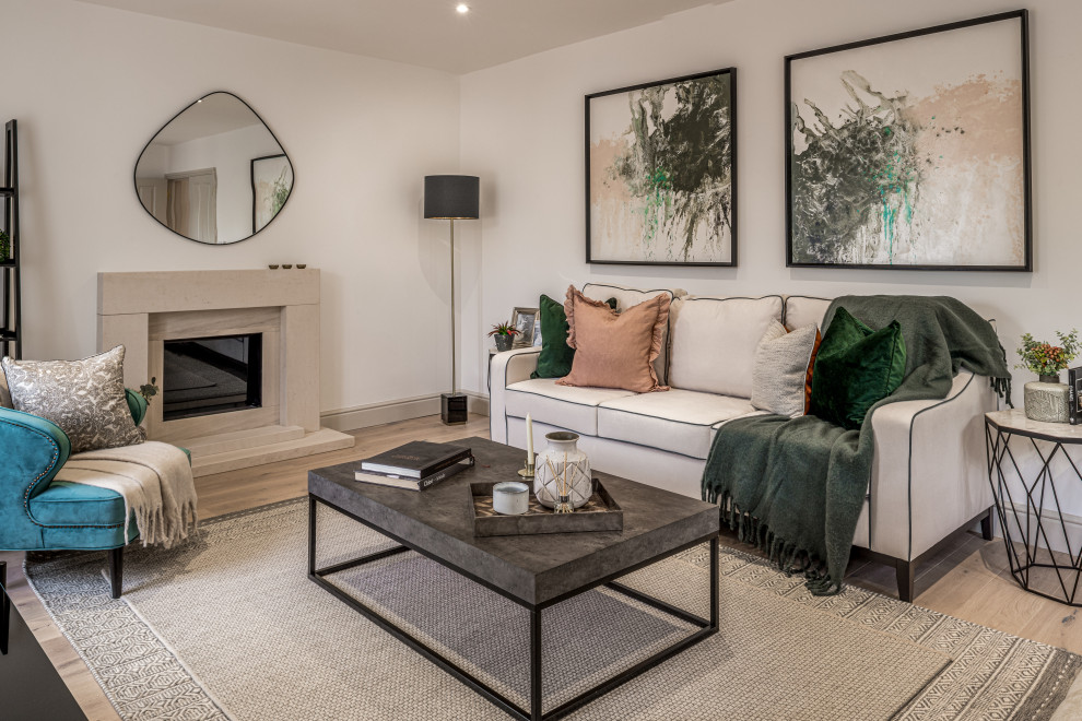Medium sized traditional formal and grey and white enclosed living room in Surrey with white walls, light hardwood flooring, a standard fireplace, a stone fireplace surround, a freestanding tv and brown floors.