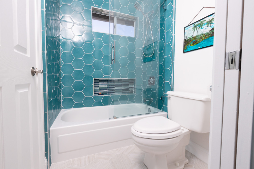 Cette image montre une salle de bain ethnique de taille moyenne pour enfant avec un placard avec porte à panneau surélevé, des portes de placard bleues, une baignoire en alcôve, un combiné douche/baignoire, un carrelage bleu, des carreaux de porcelaine, un mur blanc, un sol en carrelage de porcelaine, un lavabo encastré, un plan de toilette en quartz modifié, un sol beige, une cabine de douche à porte coulissante, un plan de toilette blanc, des toilettes cachées, meuble double vasque, meuble-lavabo encastré et du papier peint.