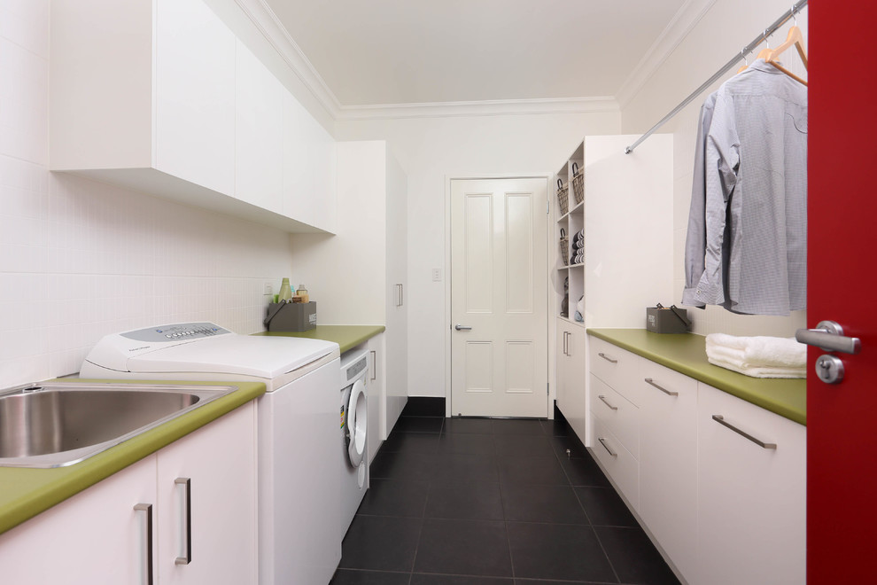 Photo of a mid-sized modern galley utility room in Brisbane with a drop-in sink, laminate benchtops, white walls, ceramic floors, flat-panel cabinets and white cabinets.