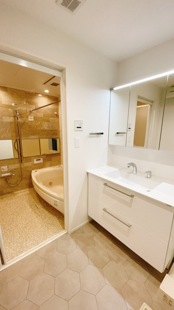 東京23区にあるお手頃価格の中くらいなモダンスタイルのおしゃれなトイレ・洗面所 (フラットパネル扉のキャビネット、白いキャビネット、一体型トイレ	、ベージュのタイル、ベージュの壁、リノリウムの床、オーバーカウンターシンク、人工大理石カウンター、グレーの床、白い洗面カウンター、独立型洗面台、クロスの天井、壁紙、白い天井) の写真