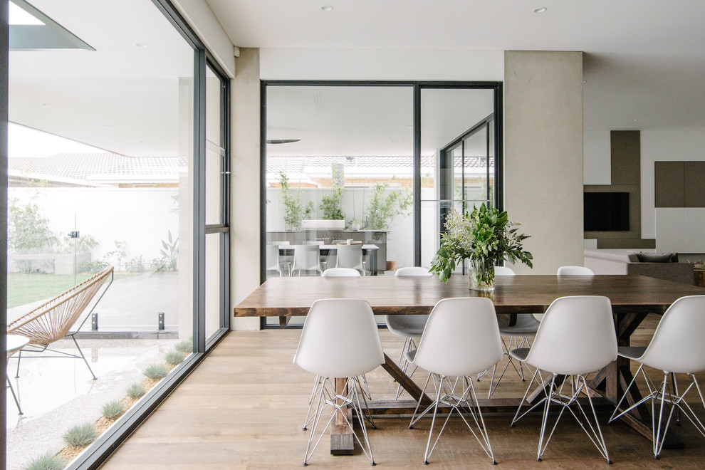 This is an example of a large contemporary open plan dining in Adelaide with white walls and dark hardwood floors.