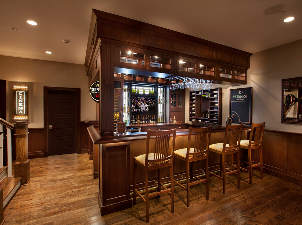 Traditional u-shaped seated home bar in DC Metro with beaded inset cabinets, medium wood cabinets, wood benchtops and brown benchtop.