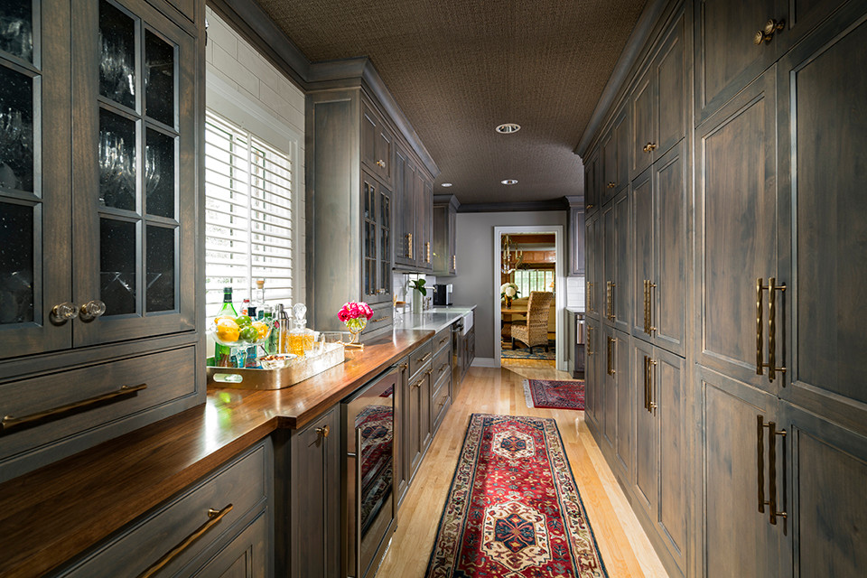 Transitional light wood floor kitchen photo with a farmhouse sink, gray cabinets, quartz countertops, white backsplash, subway tile backsplash and stainless steel appliances