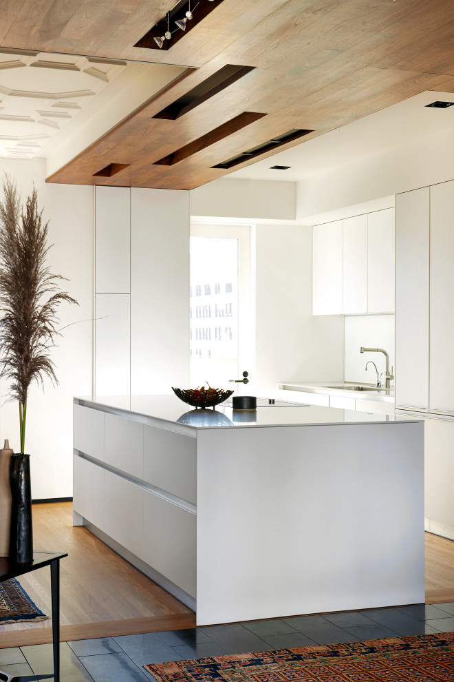 Contemporary l-shaped kitchen in San Francisco with flat-panel cabinets, white cabinets, medium hardwood floors, with island, brown floor, grey benchtop and wood.