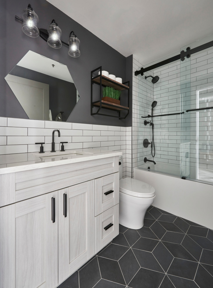 Inspiration for a medium sized classic family bathroom in Chicago with recessed-panel cabinets, grey cabinets, an alcove bath, a shower/bath combination, grey tiles, porcelain tiles, white walls, porcelain flooring, quartz worktops, grey floors, a sliding door, white worktops, a wall niche, a single sink and a freestanding vanity unit.