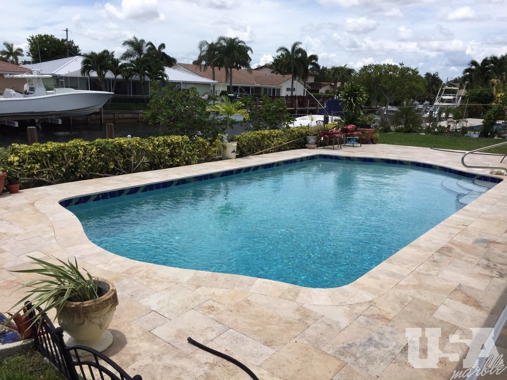 Design ideas for a mid-sized pool in Miami with natural stone pavers.