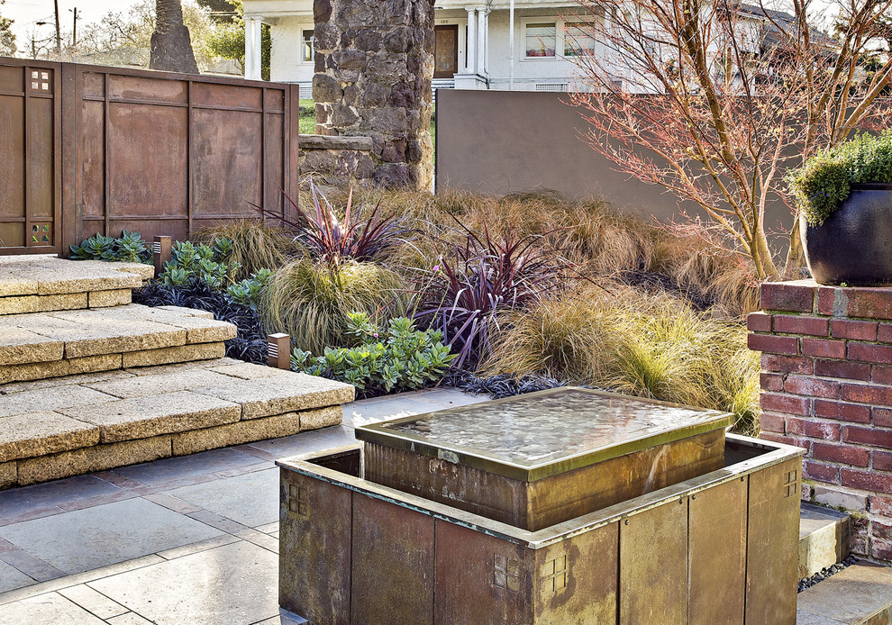 Photo of a large arts and crafts courtyard patio in San Francisco with a water feature.