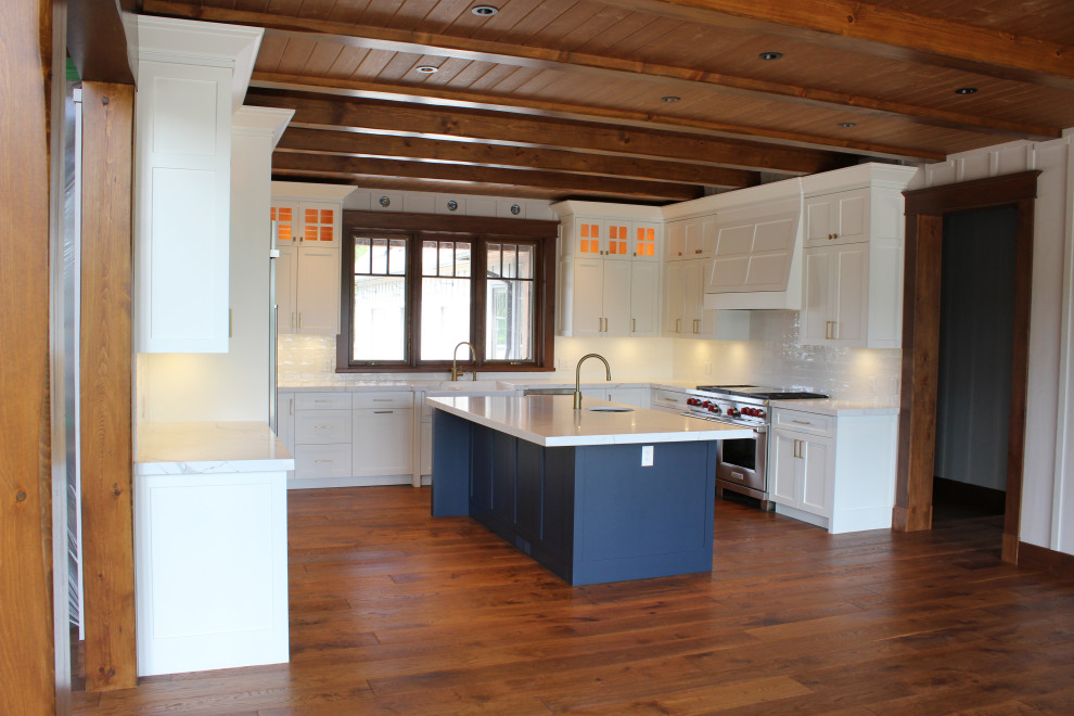 Eat-in kitchen - large rustic u-shaped dark wood floor, brown floor and wood ceiling eat-in kitchen idea in Toronto with a farmhouse sink, shaker cabinets, white cabinets, quartz countertops, white backsplash, subway tile backsplash, stainless steel appliances, an island and white countertops