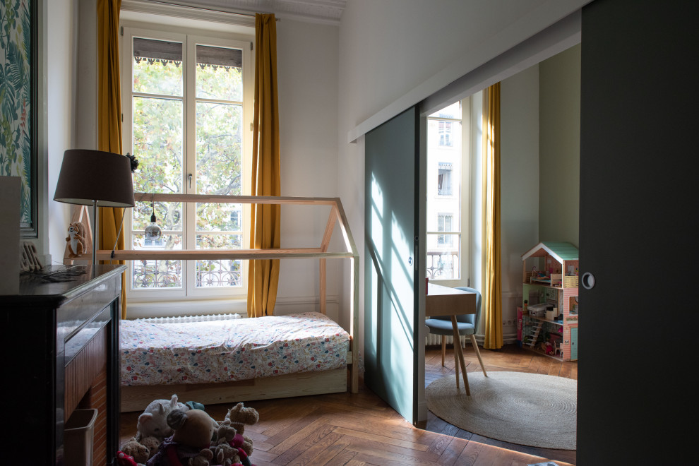 Ejemplo de dormitorio infantil escandinavo con paredes blancas y suelo de madera en tonos medios