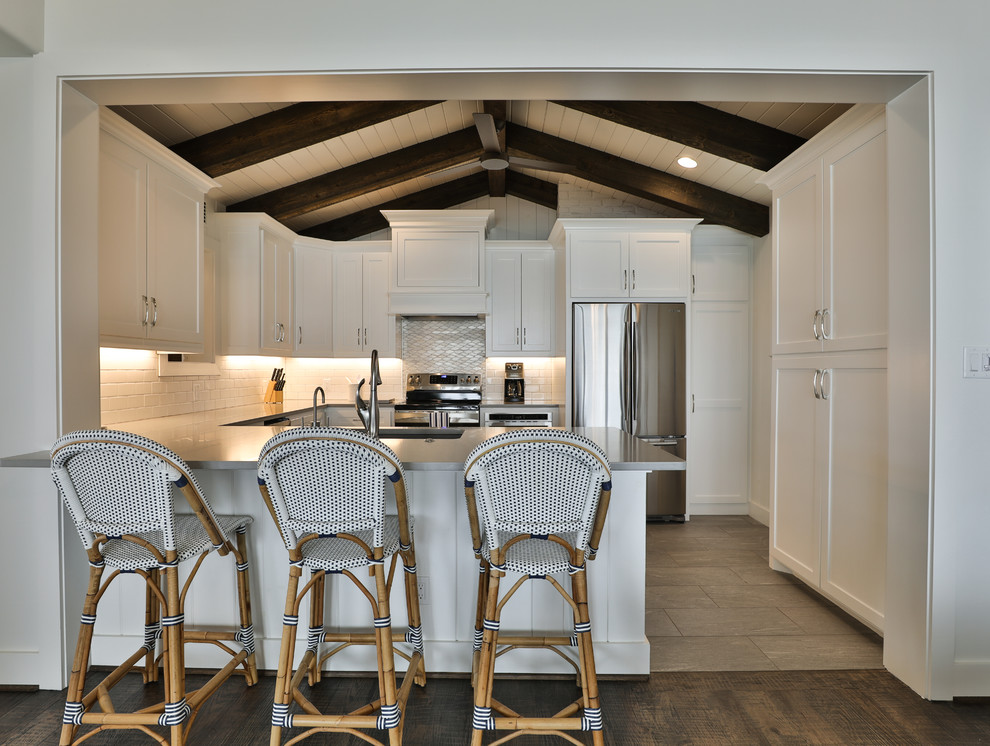 Kitchen - transitional u-shaped gray floor kitchen idea in Dallas with an undermount sink, shaker cabinets, white cabinets, white backsplash, stainless steel appliances, a peninsula and gray countertops