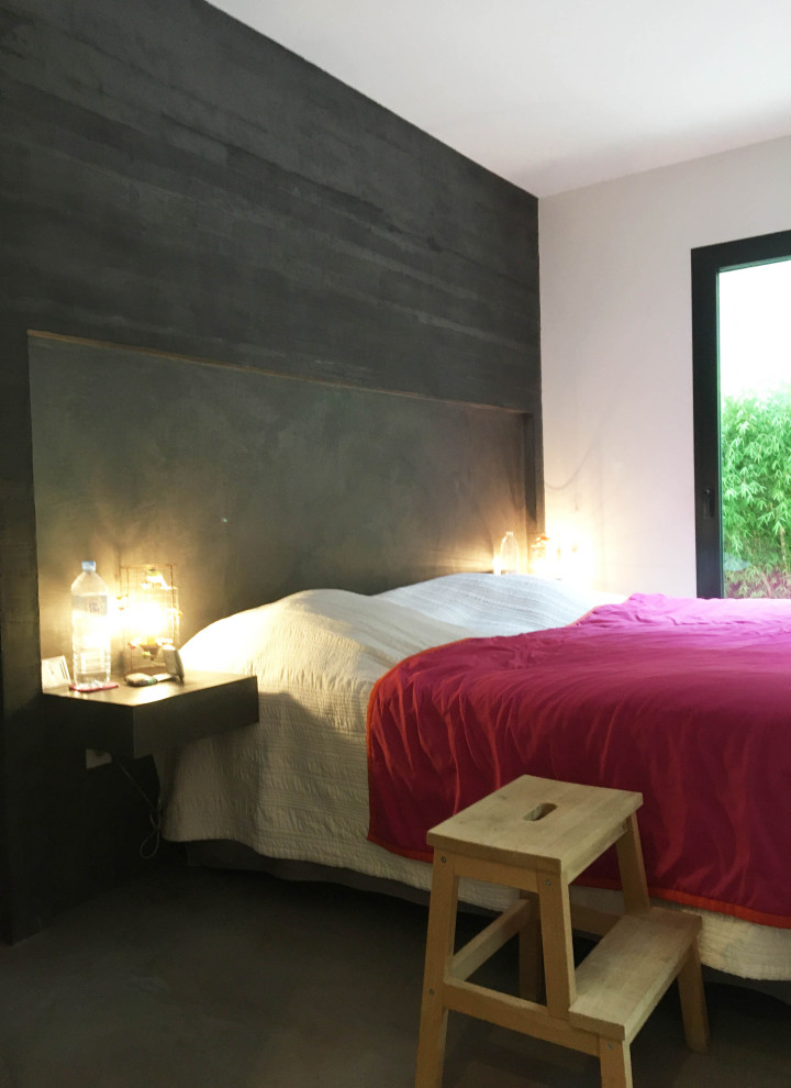 Mittelgroßes Modernes Schlafzimmer mit grauer Wandfarbe, Betonboden, Eckkamin und Kaminumrandung aus Beton in Sonstige