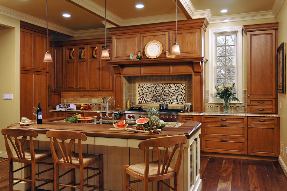 This is an example of a mid-sized traditional single-wall eat-in kitchen in DC Metro with an undermount sink, beaded inset cabinets, medium wood cabinets, granite benchtops, multi-coloured splashback, stainless steel appliances, medium hardwood floors, with island and ceramic splashback.