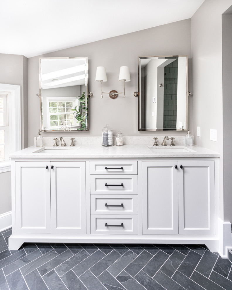 This is an example of a mid-sized transitional master bathroom in Philadelphia with flat-panel cabinets, white cabinets, a freestanding tub, an alcove shower, a two-piece toilet, white tile, subway tile, grey walls, slate floors, an undermount sink, engineered quartz benchtops, black floor, a hinged shower door, white benchtops, a shower seat, a double vanity and a built-in vanity.