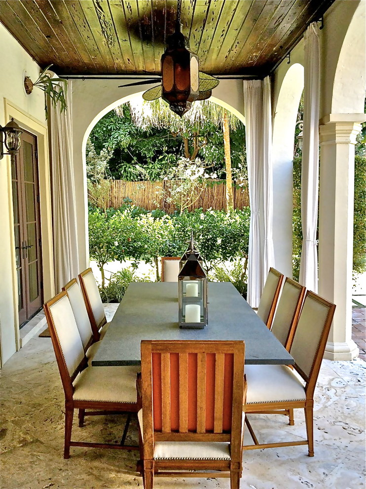 This is an example of a tropical patio in Miami with a roof extension.