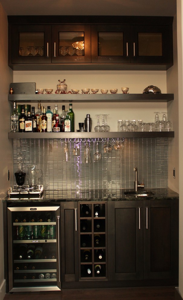 This is an example of a small contemporary wet bar in Vancouver with an undermount sink, shaker cabinets, dark wood cabinets, granite benchtops, grey splashback, glass tile splashback and dark hardwood floors.