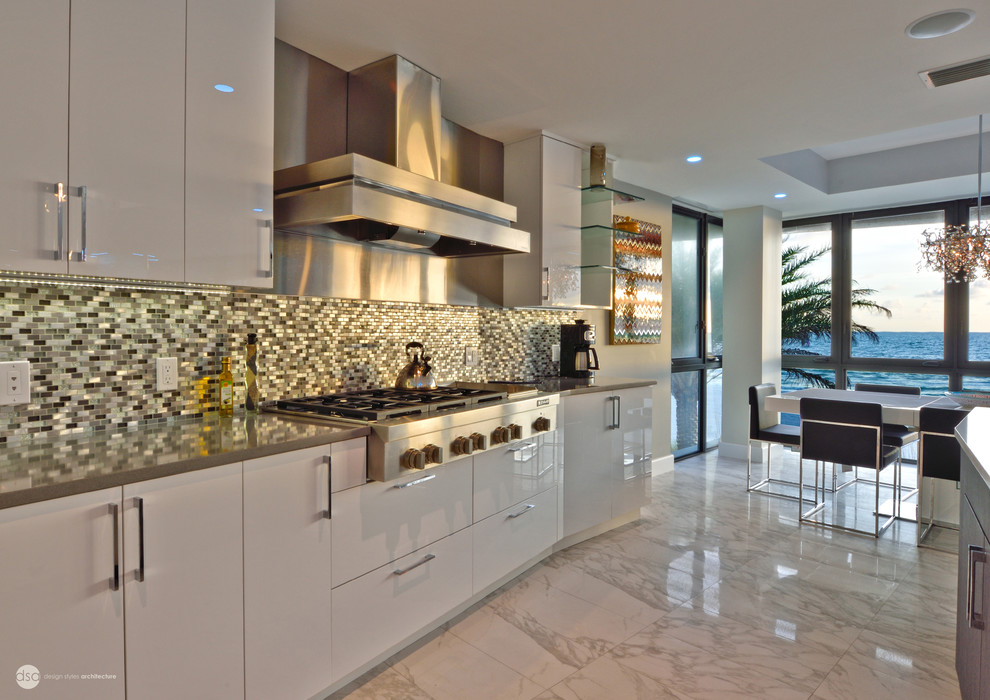 Inspiration for a contemporary u-shaped eat-in kitchen in Tampa with an undermount sink, flat-panel cabinets, white cabinets, stainless steel benchtops, multi-coloured splashback, matchstick tile splashback, stainless steel appliances, marble floors and with island.