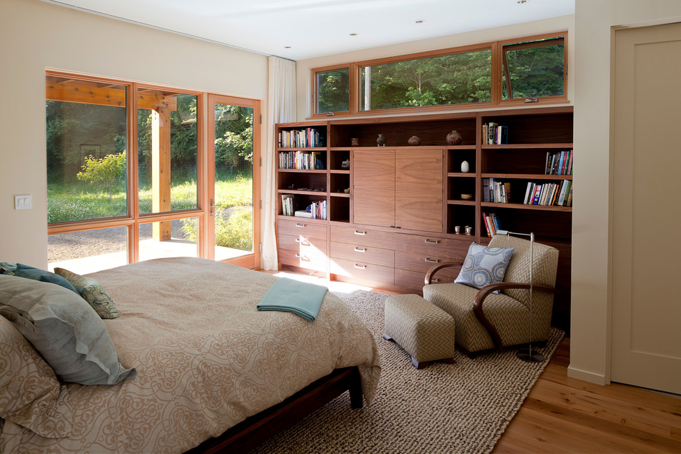 Mid-sized contemporary guest bedroom in Portland with beige walls, medium hardwood floors and no fireplace.