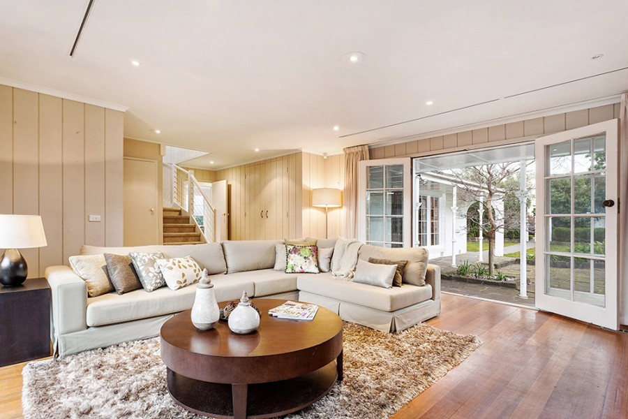 This is an example of a modern formal enclosed living room in Melbourne with beige walls, medium hardwood floors and brown floor.