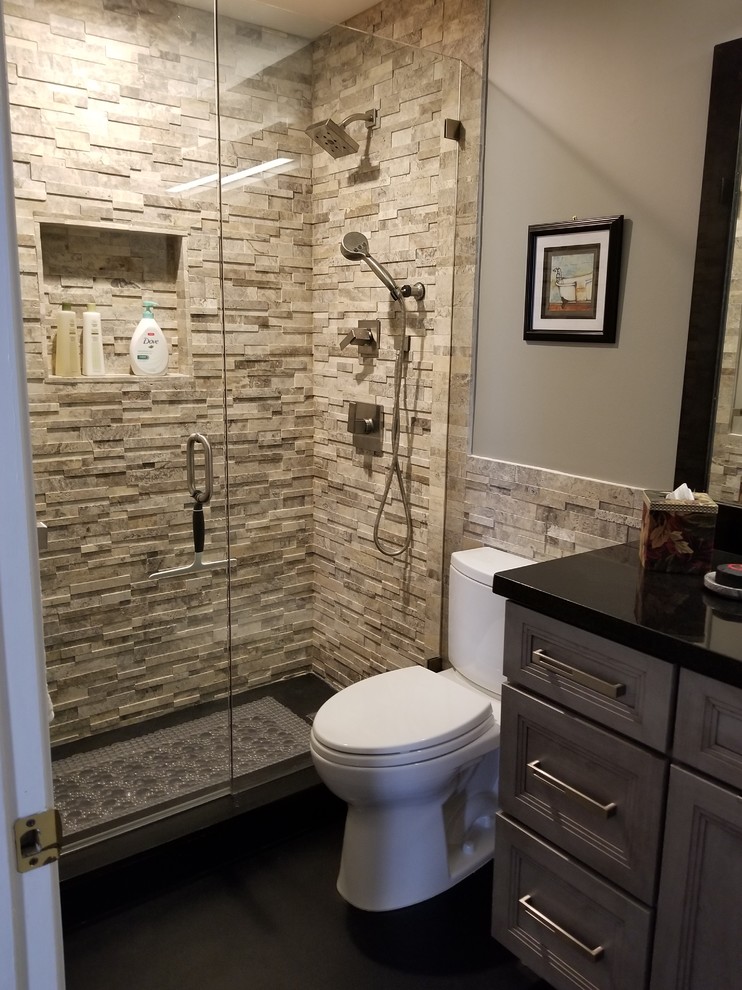 Mid-sized transitional 3/4 bathroom in Miami with recessed-panel cabinets, grey cabinets, a one-piece toilet, gray tile, stone tile, grey walls, an undermount sink, granite benchtops and black floor.