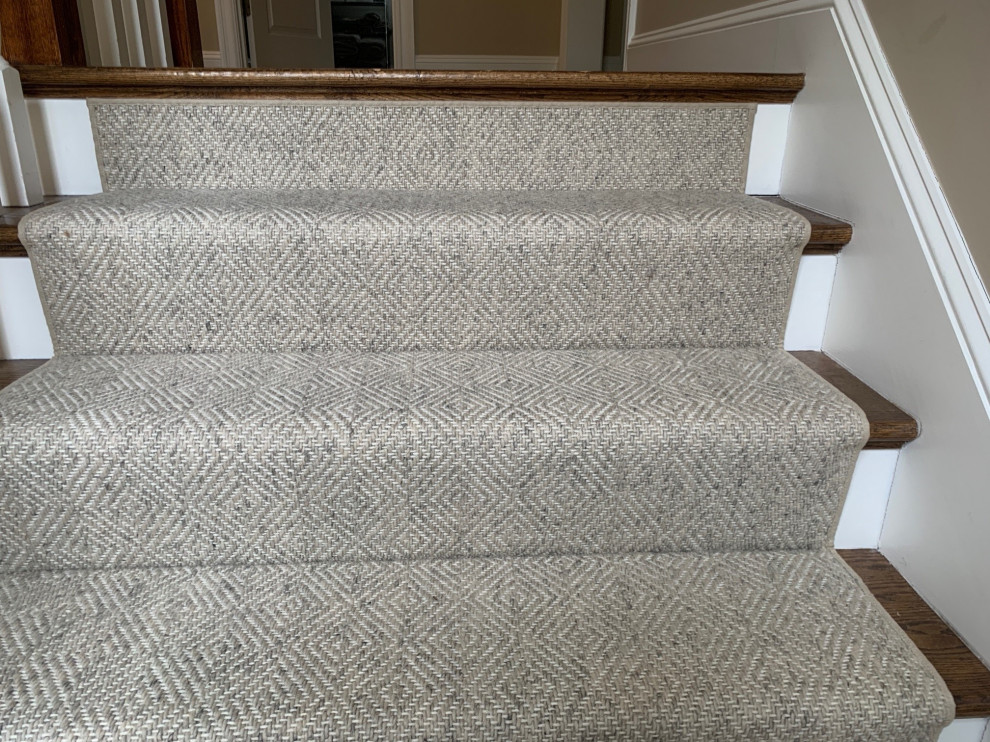 Design ideas for a carpeted l-shaped staircase in Boston with carpet risers, wood railing and panelled walls.