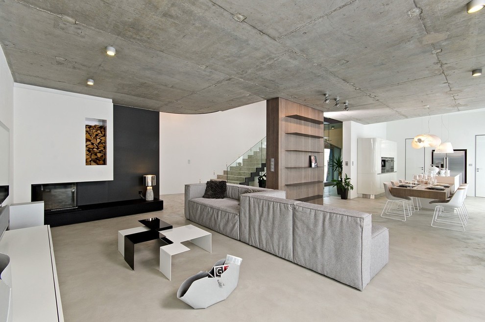 Photo of a modern open concept living room in Miami with white walls, concrete floors and a standard fireplace.