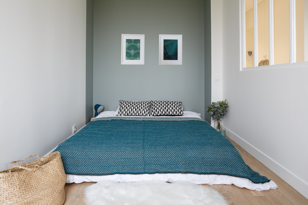 Ejemplo de dormitorio principal nórdico pequeño con paredes verdes y suelo de madera clara