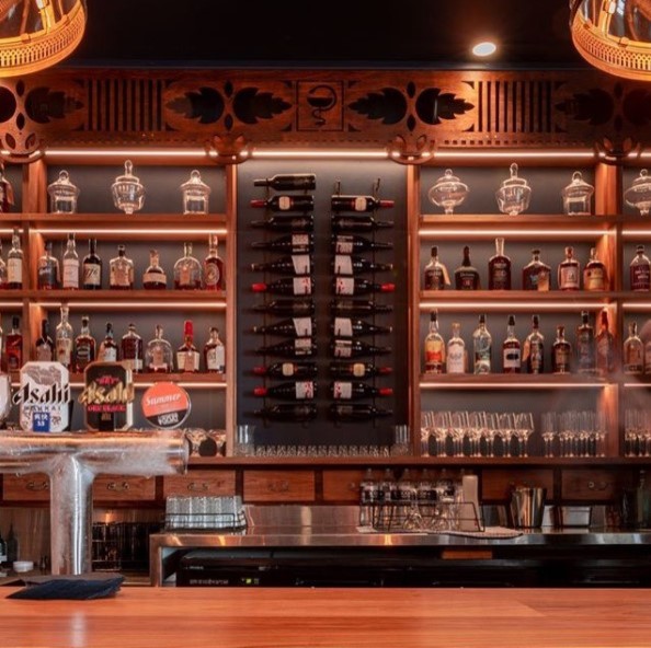 Photo of a mid-sized traditional galley seated home bar in Brisbane with medium wood cabinets, wood benchtops, medium hardwood floors, brown floor and brown benchtop.