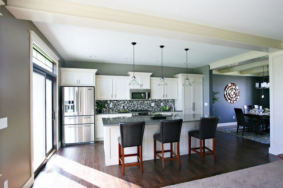 Kitchen - single-wall dark wood floor kitchen idea in Chicago with an undermount sink, shaker cabinets, white cabinets, granite countertops, stainless steel appliances and an island