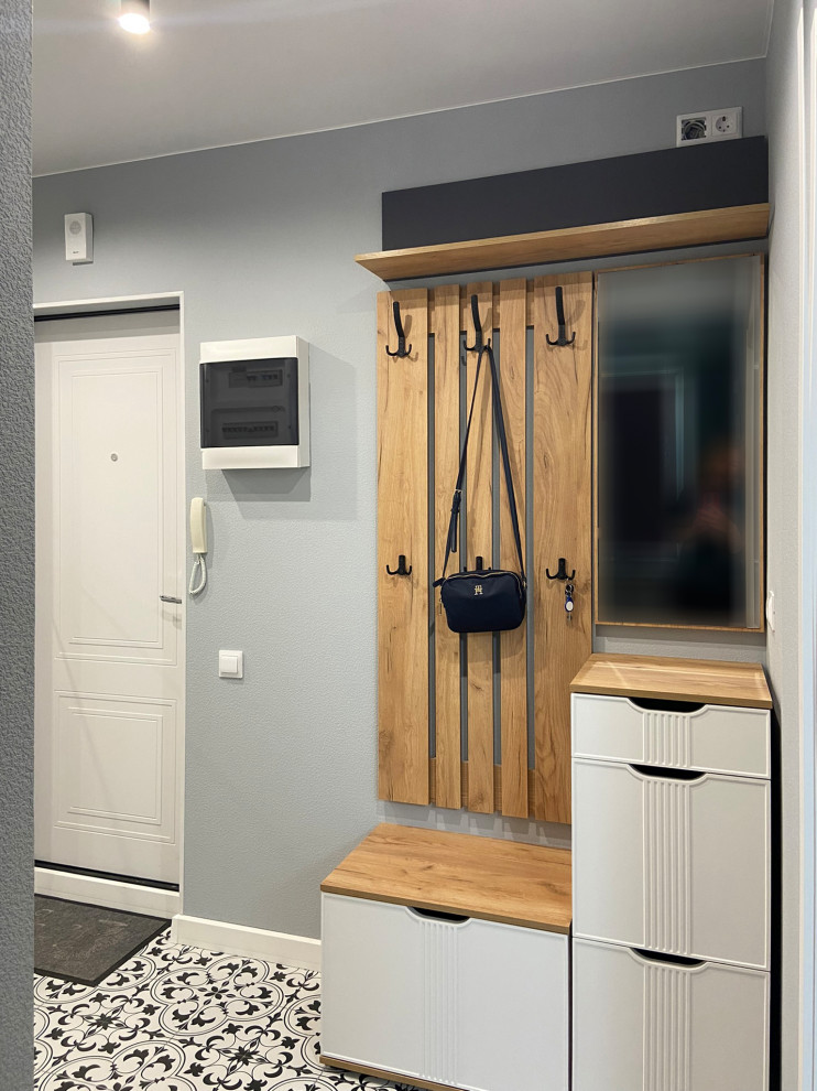 Свежая идея для дизайна: входная дверь со шкафом для обуви в современном стиле с серыми стенами, полом из керамической плитки, одностворчатой входной дверью, белой входной дверью и панелями на части стены - отличное фото интерьера