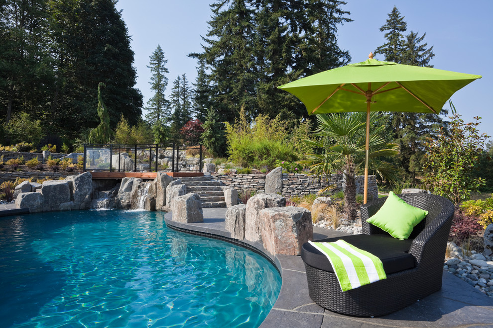 Inspiration for a transitional backyard custom-shaped pool in Vancouver with stamped concrete.