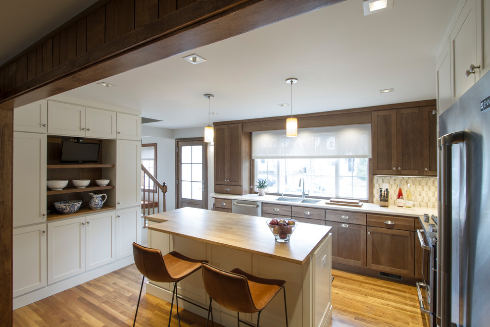 Mid-sized transitional l-shaped open plan kitchen in Philadelphia with an undermount sink, recessed-panel cabinets, white cabinets, quartzite benchtops, beige splashback, mosaic tile splashback, stainless steel appliances, light hardwood floors, with island, brown floor and brown benchtop.