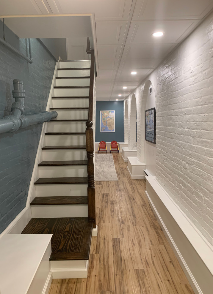 Design ideas for a mid-sized transitional fully buried basement in New York with blue walls, vinyl floors and brown floor.