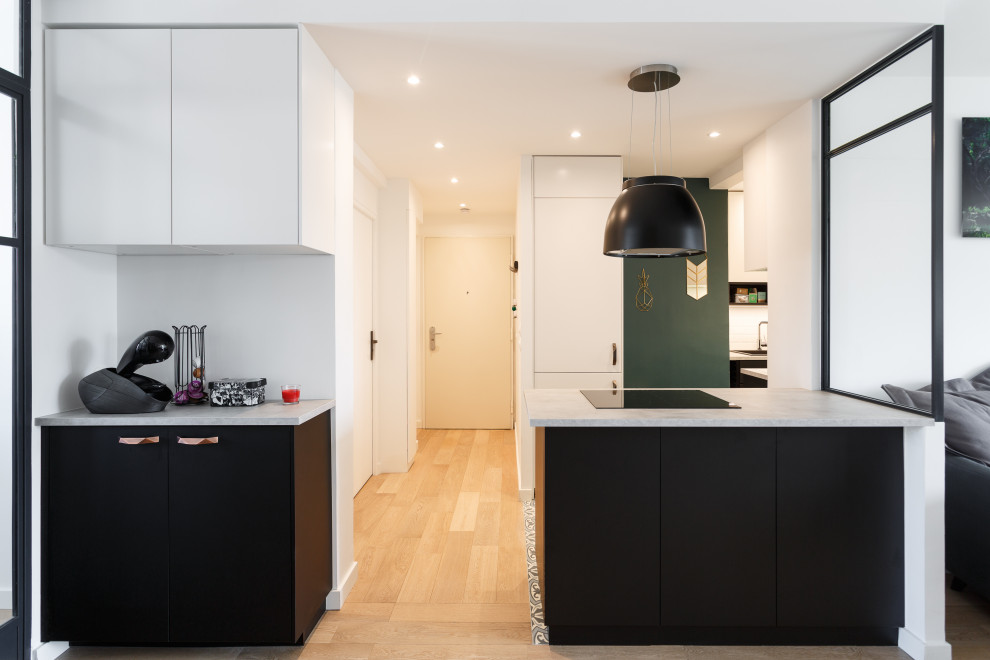 Mid-sized contemporary u-shaped open plan kitchen in Other with a drop-in sink, flat-panel cabinets, black cabinets, marble benchtops, white splashback, subway tile splashback, panelled appliances, cement tiles, a peninsula, grey floor and white benchtop.