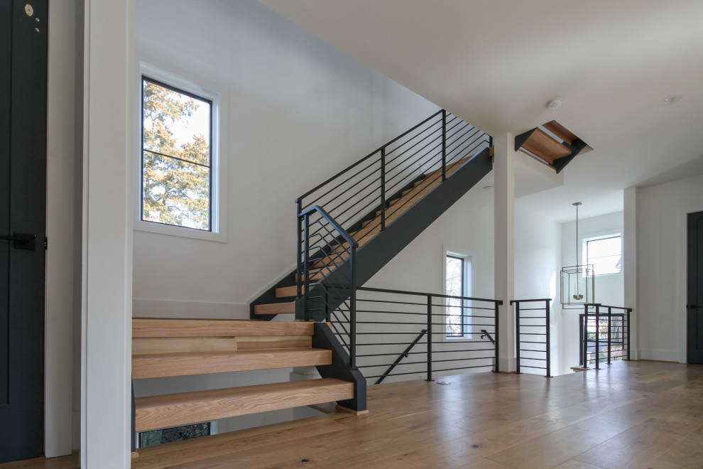 Foto de escalera recta actual de tamaño medio con escalones de madera y barandilla de metal