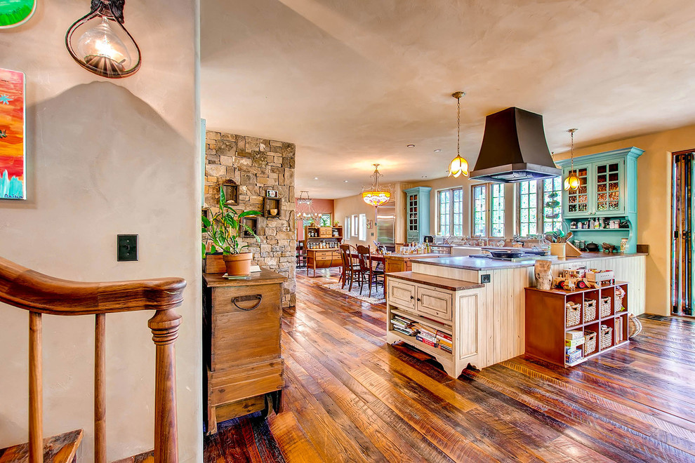 Photo of a traditional l-shaped open plan kitchen in Denver with a farmhouse sink, beaded inset cabinets, distressed cabinets, beige splashback, stainless steel appliances, no island and brown floor.