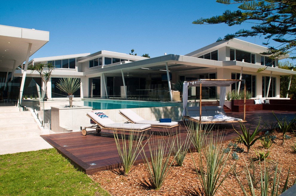 Large modern backyard partial sun formal garden in Sydney with decking for summer.