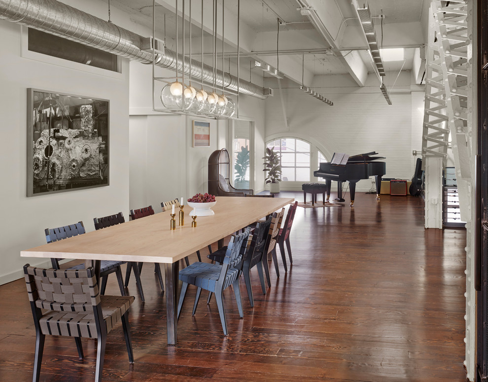 Design ideas for an expansive industrial open plan dining in San Francisco with white walls and medium hardwood floors.