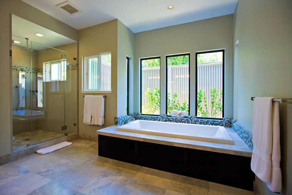 This is an example of a large contemporary master bathroom in San Francisco with an undermount sink, granite benchtops, a drop-in tub, an alcove shower, a one-piece toilet, gray tile, mosaic tile, green walls, porcelain floors, louvered cabinets, dark wood cabinets, grey floor, a hinged shower door and grey benchtops.