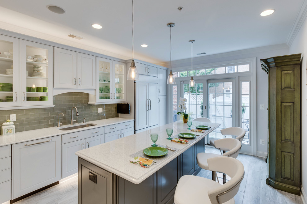 Photo of a large transitional l-shaped kitchen in DC Metro with an undermount sink, raised-panel cabinets, quartz benchtops, green splashback, subway tile splashback and with island.